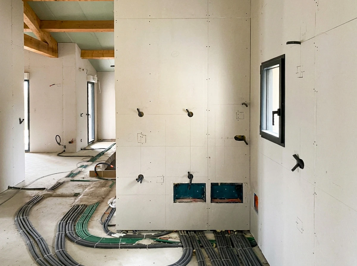 Espace de travail d'électricien avec plans architecturaux étalés sur table