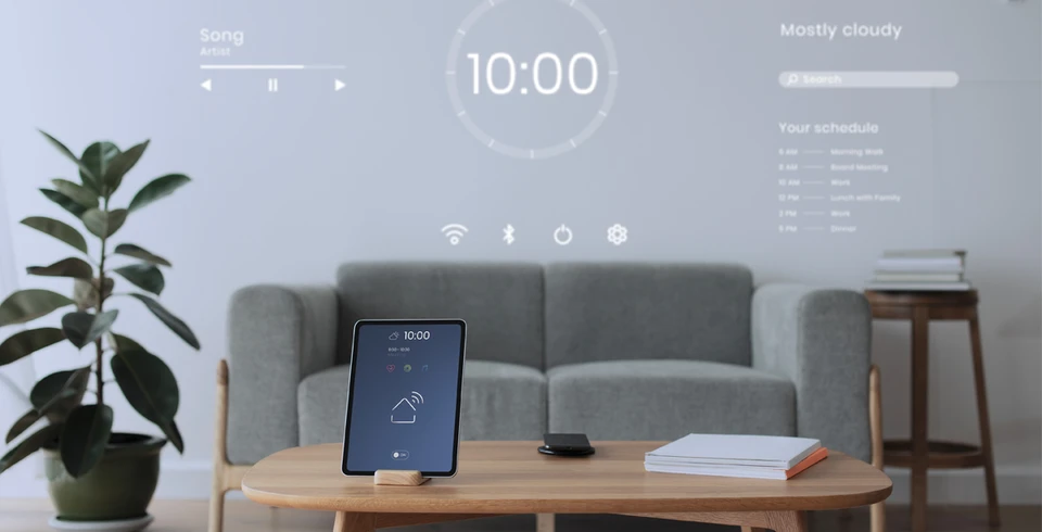 Photographie d'une main d'une personne effectuant un geste sur une tablette tactile moderne affichant une interface de contrôle domotique avec plusieurs fonctions (éclairage, température, volets, scénarios) visibles à l'écran, prise dans un intérieur résidentiel contemporain avec ambiance chaleureuse d'un salon ou d'une cuisine bien éclairé.
