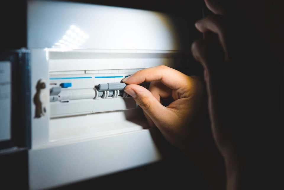 Électricien professionnel en chemise à carreaux travaillant avec des équipements électriques
